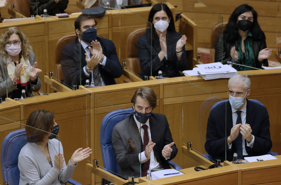 El conselleiro de Hacienda, Miguel Corgos recibe el aplauso de su grupo tras aprobar el pleno del Parlamento de Galicia los presupuestos generales