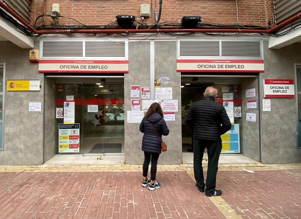 Dos personas, delante de una oficina de empleo en Madrid