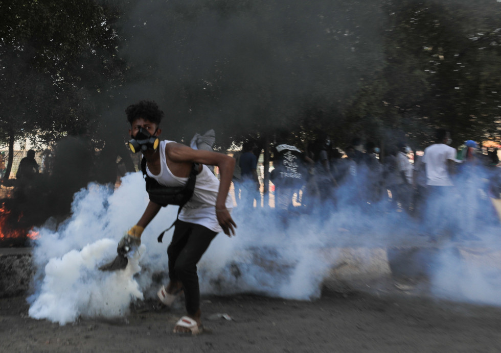 Un manifestante intenta devolver un bote de gas lacrimógeno lanzado por policías antidisturbios durante una nueva jornada de protestas contra el golpe de Estado militar del pasado 25 de octubre, hoy