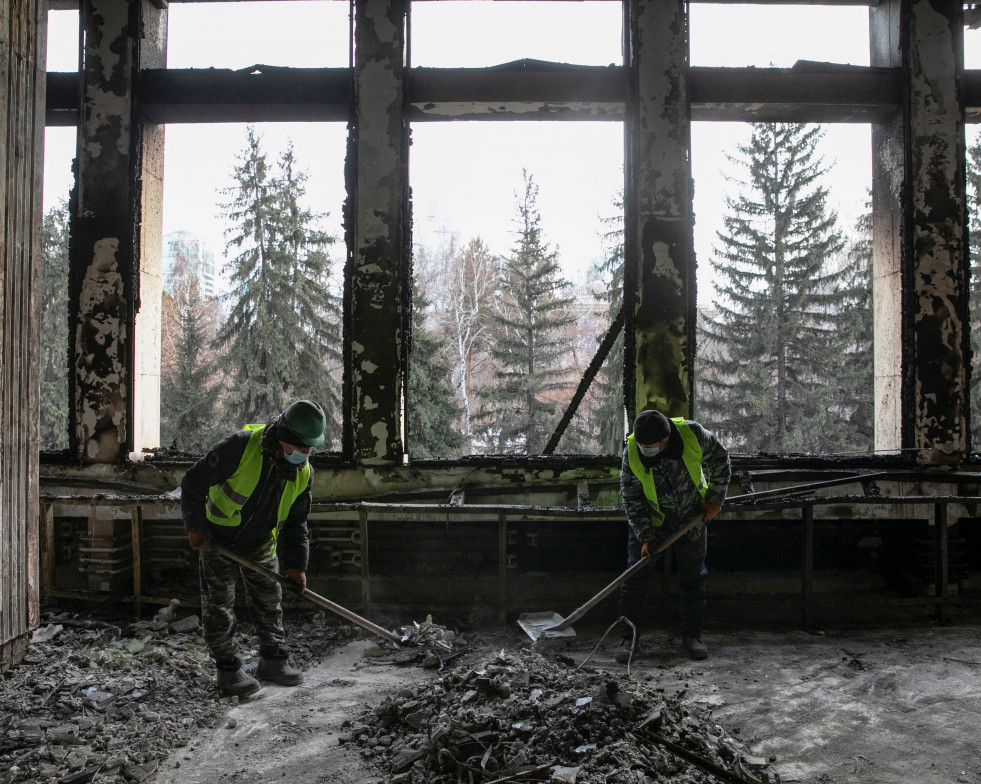 Dos trabajadores eliminan los escombros en el Ayuntamiento de Almaty, Kazajistán